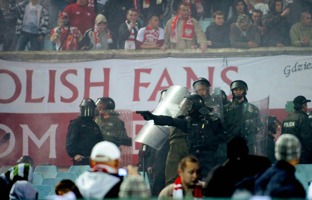 Slovakian policeman points a weapon at Polish fans before their 2010 World Cup qualifying football match 