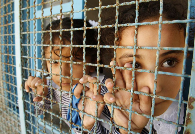 Palestinian students look through the window of their classroom at the United Nations Relief and Works Agency for Refugees (UNRWA) school    