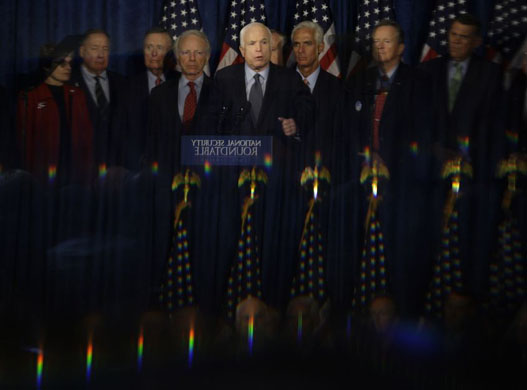 ohn McCain is reflected in a mirror in the back of the room as he makes a statement after participating in a National Security Roundtable