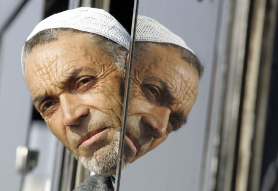 A Kashmiri Hajj pilgrim looks from bus window before they depart for Mecca  