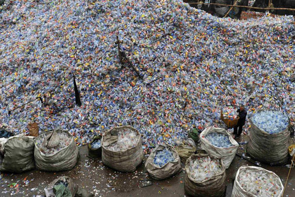 Wuhan, China: A worker amidst plastic bottles at a recycling plant   