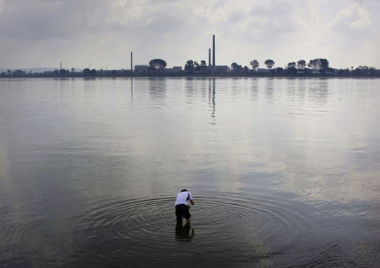 A fisherman sets his trap in the Yalu River, opposite the North Korean town of Sinuiju