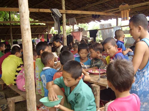 Children enjoying a meal in the border refugee camp of Mae Sot. The camp was set up one month before the cyclone hit