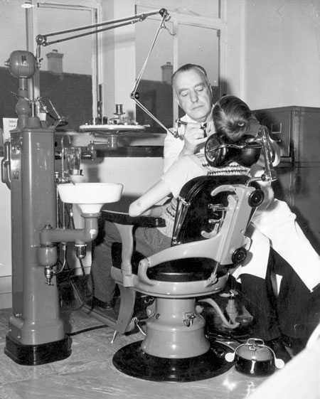 A dentist at work on a young patient in the Woodberry Down Health Centre in London
