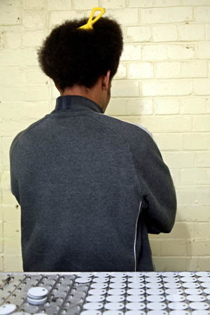 Sammy, print workshop technician. Making numerical tags. Mainly for keys. £9.00 per week