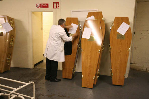 Documentation being filled out in storage room before coffins are ready to be used