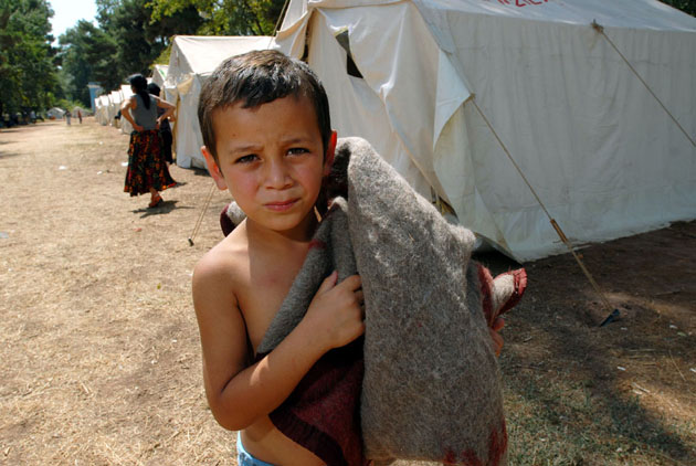 Dato, 6, carries a blanket for a makeshift bed
