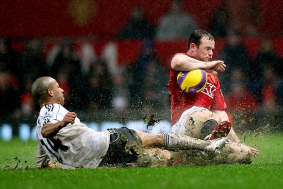 Tyrone Mears and Wayne Rooney compete for the ball