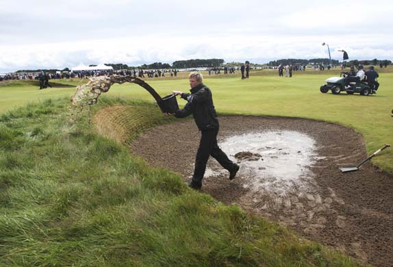 A groundsman bails water
