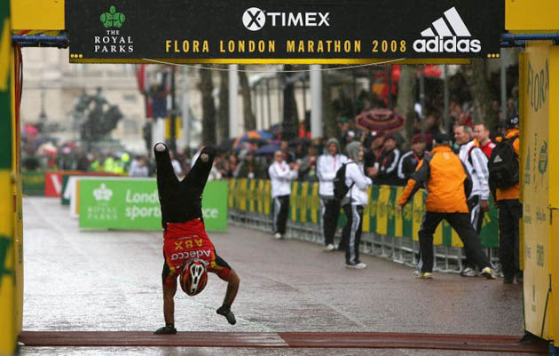 Shaho Qadir of Great Britain crosses the finish line of the London marathon on his hands to complete the wheelchair race