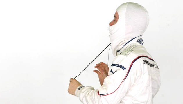 BMW Sauber Formula One driver Nick Heidfeld of Germany adjusts his balaclava during a test session