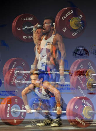 Bronze medalist Belgium's Tom Goegebuer competes in men's 56 kg weightlifting category