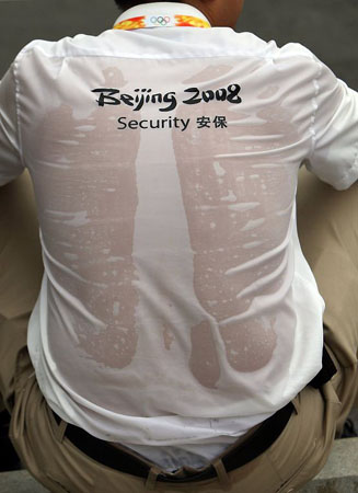 A security official takes a breather at the Olympic Green