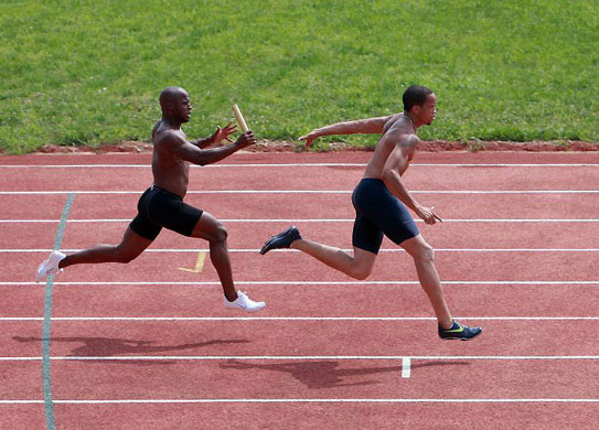 US sprinter Wallace Spearmon practices relay with his teammate Rodney Martin