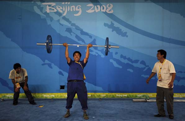 worker tests his strength lifting weights