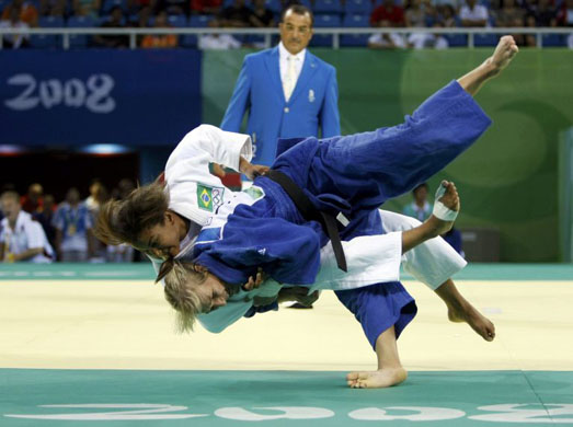 Eva Csernoviczki of Hungary (blue) throws Sarah Menezes of Brazil in the air during their Women -48kg preliminary judo fight at the Beijing 2008 Olympic Games