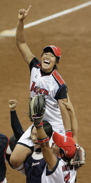 Japan team lifts pitcher Yukiko Ueno while celebrating winning the gold medal against the USA 