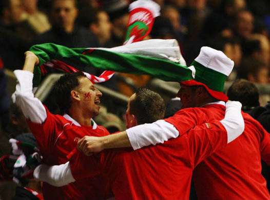 Wales fans celebrate after their team secures victory during the RBS Six Nations Championship match between England and Wales at Twickenham