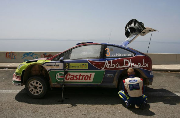 Finland's driver Mikko Hirvonen changes a tire on his Ford Focus RS WRC 07 on the highway about 37 miles west of Athens