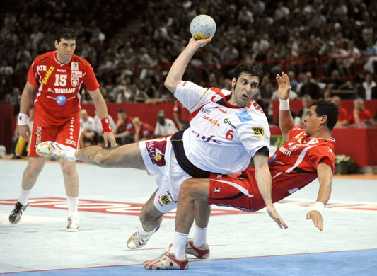 Spanish's player Garabaya (C) scores against the Tunisian's player Gharbi (R) during their Olympics Games 2008 qualifyinq Handball match