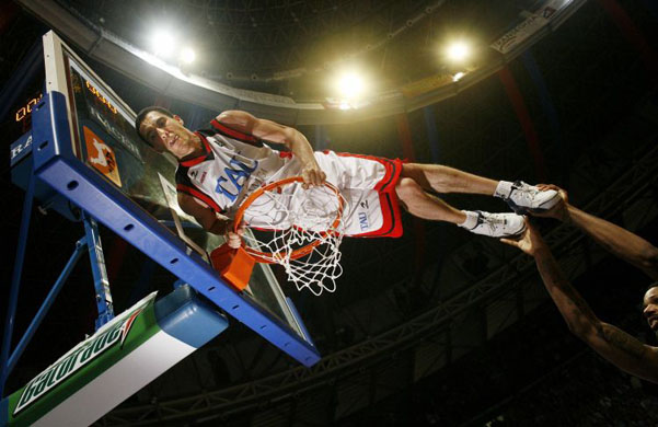 TAU Baskonia's Prigioni is helped up to undo the net after beating Barcelona and winning the Spanish basketball league