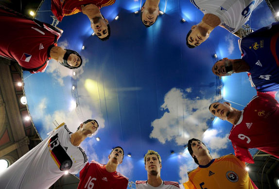 Giant inflatable soccer players  are suspended in the hall of the main station in Zurich