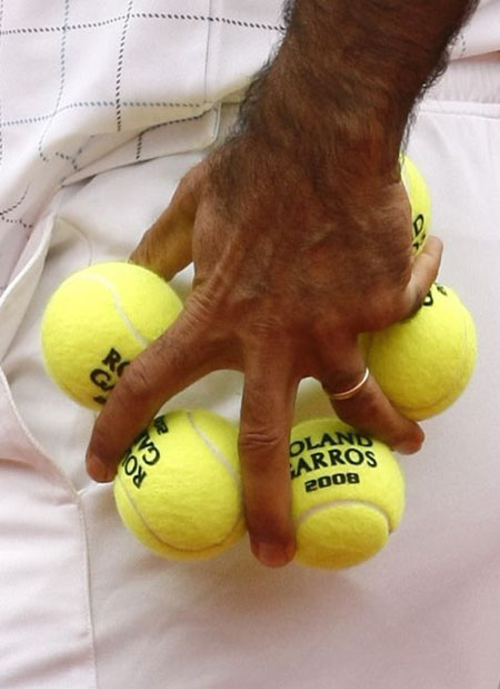 Iran's Mansour Bahrami holds 5 tennis balls between his fingers in Paris 