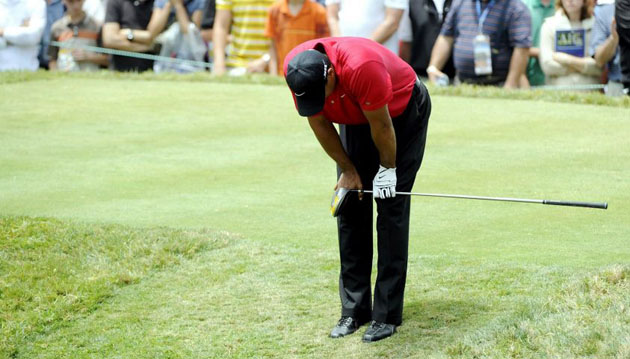 Tiger Woods of the US bends over after hitting his tee shot at US Open 