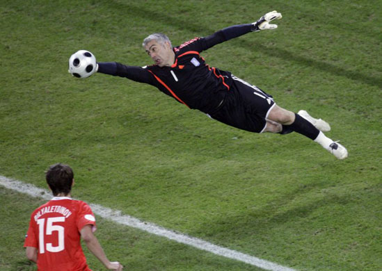 Greece's goalkeeper Antonis Nikopolidis dives to reach for the ball in Salzburg 