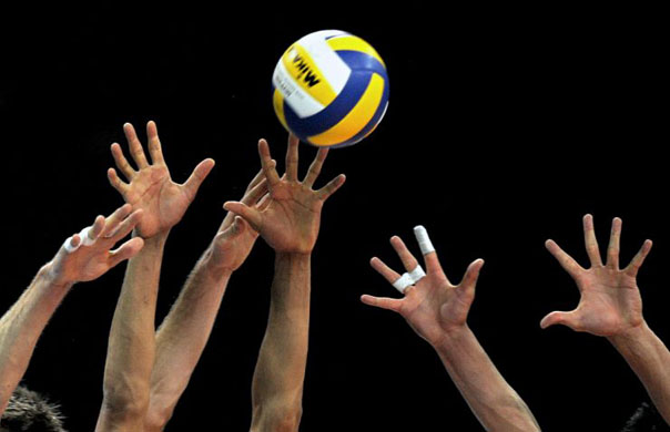 Players of French volleyball national team try to block a Venezuelan spike during a match in Caracas
