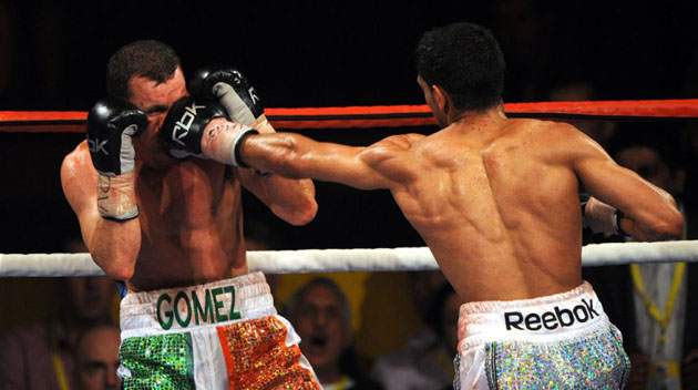 Britain's Amir Khan (R) lands a punch on compatriot Michael Gomez in Birmingham 