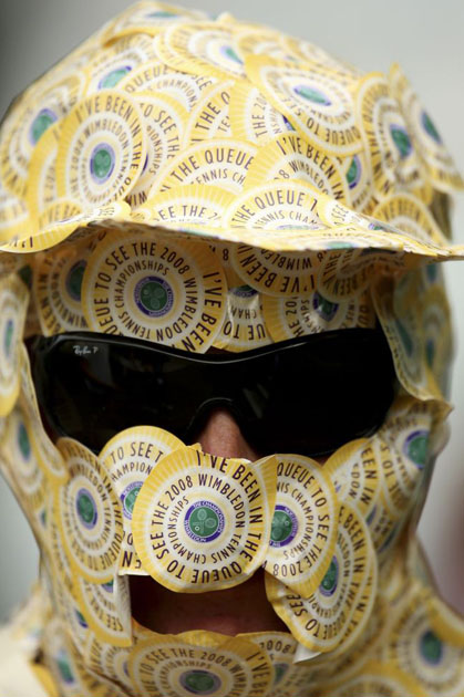 A Wimbledon fan is covered in stickers