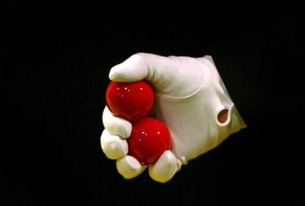 The match referee holds two red balls