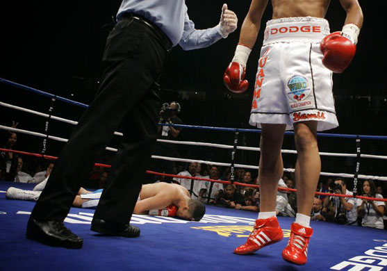 Cesar Figueroa lies on the canvas after being knocked out in 47 seconds by Junior Featherweight champion Juan Manuel Lopez