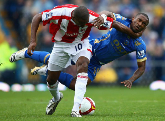 Jermain Defoe of Portsmouth tackles Ricardo Fullerof Stoke City