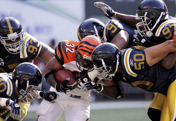 Cincinnatti Bengals' Cedric Benson surrounded by New York Jets players