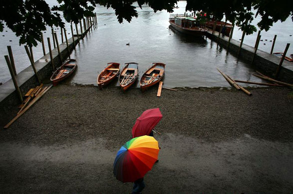 Holidaymakers walk along the shore of Ullswater in the Lake District