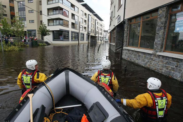 Residents of apartments next to the river Barrow use civil defence inflatable boats to go to work as flooding hits Carlow Town in Northern Ireland