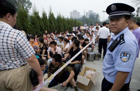 A police officer watches over the queue