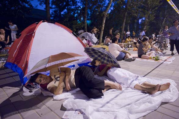 Women rest under umbrellas