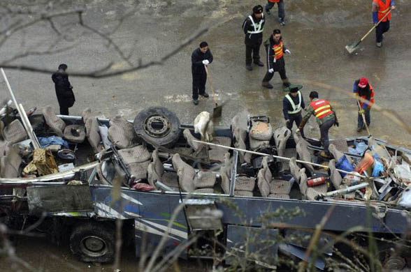 People look at the wreck of a bus in China