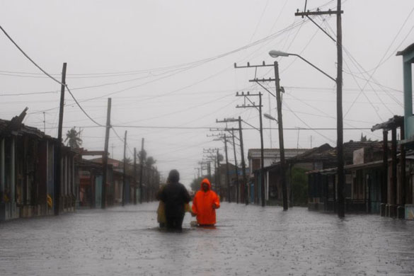 Batabano, Cuba: People walk through flooded streets during strong rain