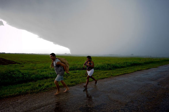 Surgidero de Batabano, Cuba: People carry belongings along the highway after evacuating their flooded village