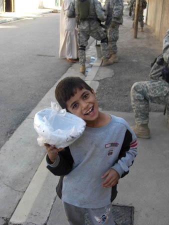 An Iraqi child smiles after being given a new football by soldiers
