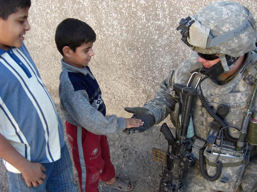 A soldier from the 3rd battalion meets Iraqi children during a 'hearts and minds' patrol