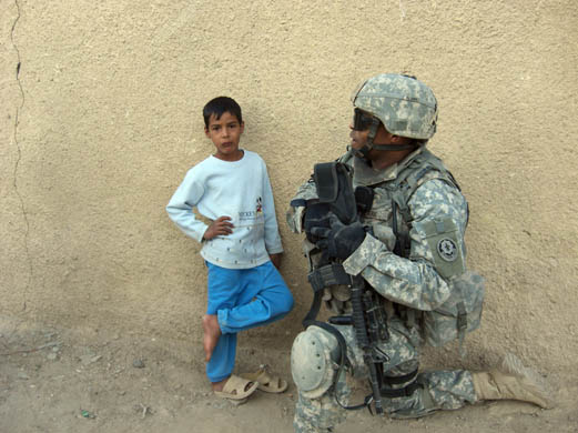 A soldier from the 3rd battalion meets an Iraqi child during a 'hearts and minds' patrol