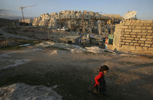 A Palestinian girl plays next to her house