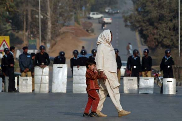 A woman and child pass a policeman