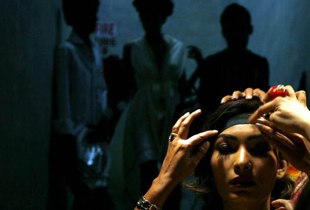 Mumbai, India: Make-up artists help a model prior to a show during the Lakme Indian Fashion Week