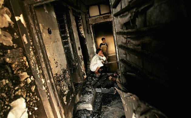 Baghdad, Iraq: A man in a burnt out room in the Sadr City Shiite district. The building was struck during a US air strike